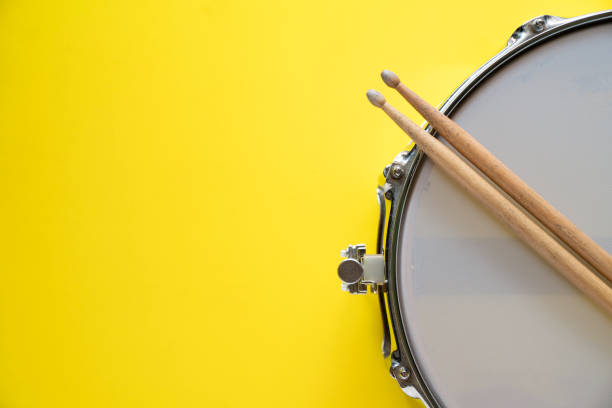 istock Drum stick and drum on yellow table background, top view, music concept 1200746771