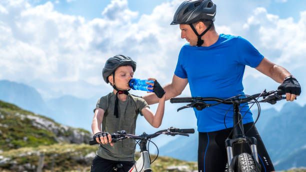 istock Father and son taking a break during mountain biking 1200748130