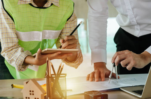 istock engineer and architect team drawing and planning about building plan with blueprint, construction tools on conference table at construction site, contractor, engineering, and construction concept 1200749219
