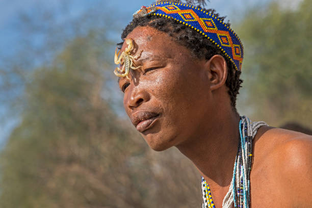 Bushman/San with a scorpion in Makgadikgadi, Botswana, Africa Makgadikgadi, Botswana - October 24, 2018:  Male Bushman/San showing a scoripion on his face, he is dressed in traditionial clothing of the San tribe. The San belong to the bushman people. bushmen stock pictures, royalty-free photos & images