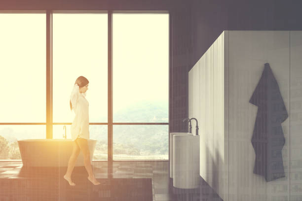 istock Woman walking in loft black and white bathroom 1200750156