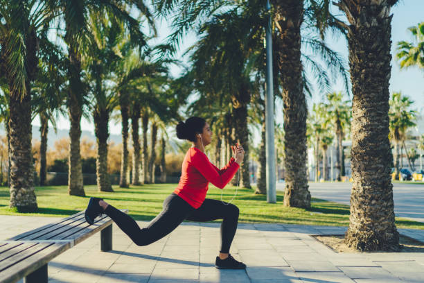 Mixed race woman in Barcelona exercising in the city Woman working out in the city park lunge stock pictures, royalty-free photos & images