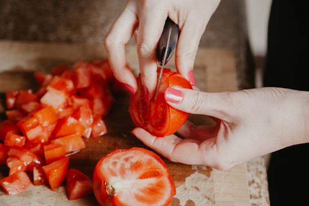 istock Woman hands cut red tomato 1200751169