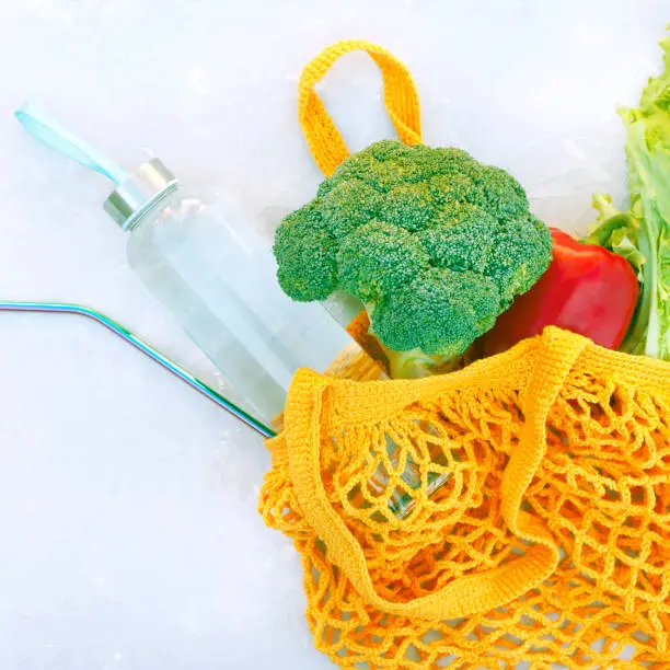 Photo of Eco bag with vegetables a bottle of water and an eco straw.