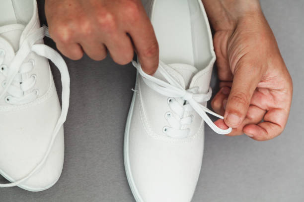 istock Hands tie  lace on new white sneaker 1200752874