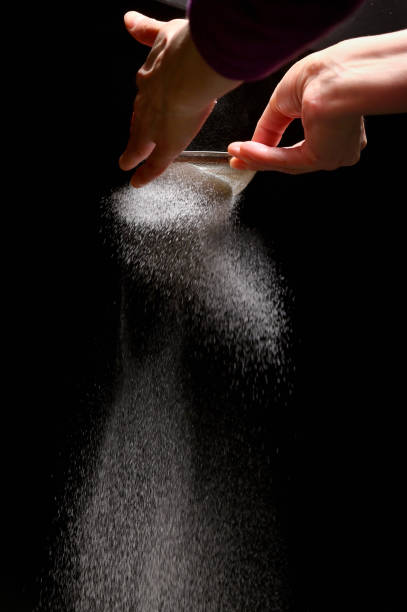 istock Sugar Powder Splashes By Woman Hand On Black Background 1200753933