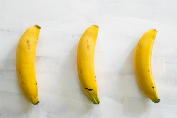 istock bananas on white wooden table 1200754304