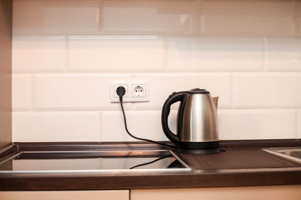 istock Modern kitchen with metal sink, kettle and white decorative wall, electric cooker 1200759817