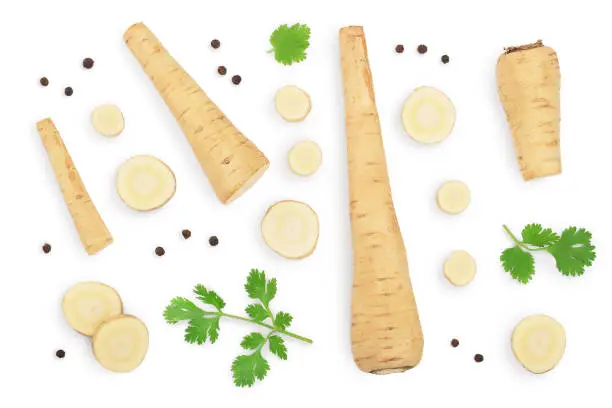 Parsnip root and slices with parsley peppercorns isolated on white background with clipping path. Top view. Flat lay..
