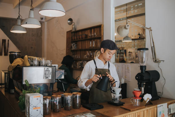 concentrazione di barista hipster asiatico che aggiunge acqua calda nel gocciolamento del caffè sopra il barattolo di vetro - asian country foto e immagini stock