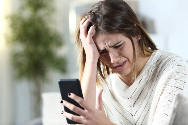 istock Sad girl complaining holding smart phone at home 1200762303