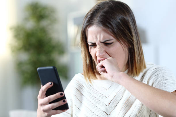 istock Angry girl holding smart phone at home 1200762313