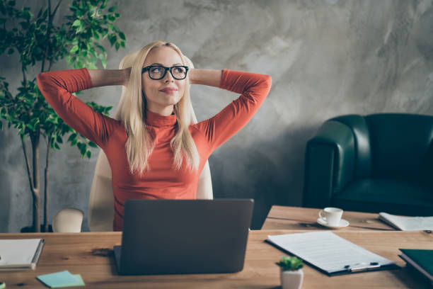 istock Minded secretary beautiful woman finish start-up work boss project look stretch hands think when weekends rest relax sit table wear red turtleneck in office workstation 1200763595