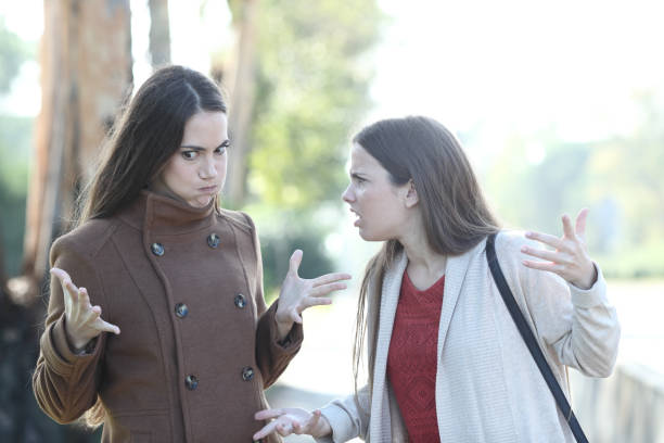 istock Two angry women arguing in a park 1200764160
