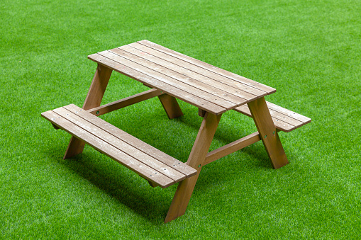 The wood chair, set on synthetic grass.