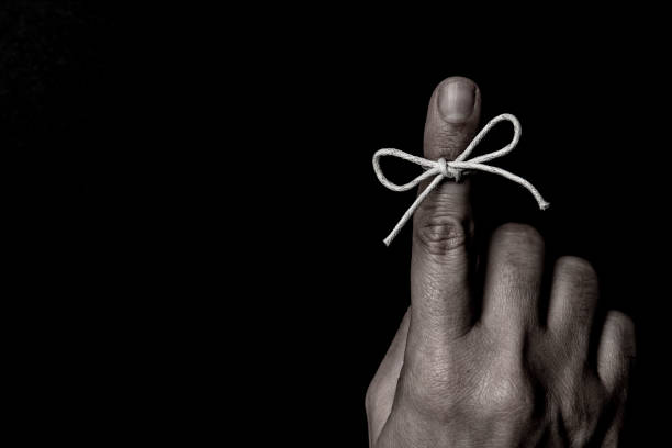 string bow tied on index finger - reminder memories human finger string imagens e fotografias de stock