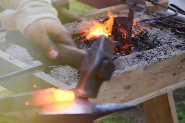 Blacksmith horn outdoors with burning coals, follow focus