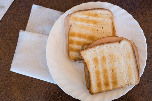 white plate with sandwich, white bread.