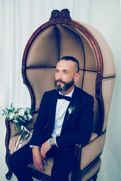 istock brooding groom waiting for his bride sitting in a chair 1200767292