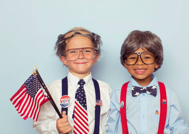 Old Boy Voting Booth Workers Two young boys dressed as a United States of America election workers and wearing eyeglasses, wigs, and suspenders smile at the camera as they are dreading the upcoming election season. With all the hate and disdain for politicians, they look forward to seeing the democratic process work. comb over stock pictures, royalty-free photos & images