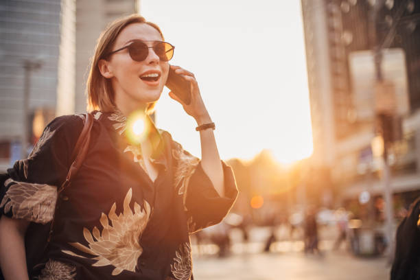 istock Happy young woman is talking on phone 1200767528