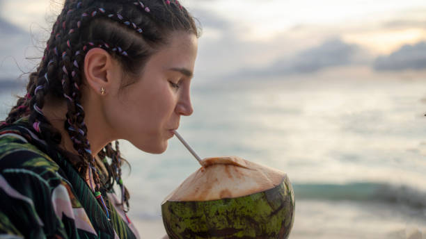 istock Female tourist on beach vacation with coconut 1200767907