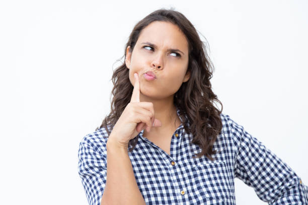 istock Thoughtful young woman with finger on cheek 1200770064