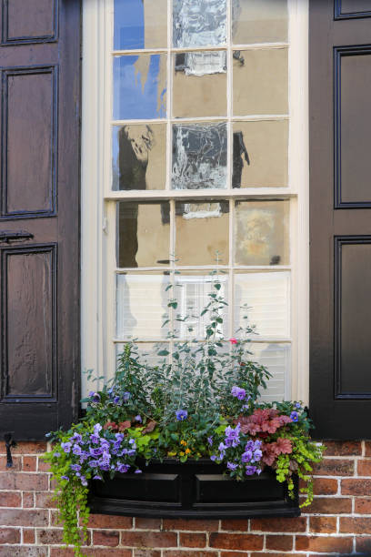 istock Reflections in old leaded glass window panes make colorful abstractions above a box overflowing with winter flowers. 1200770837