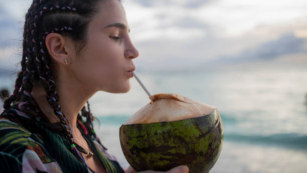 istock Female tourist on beach vacation with coconut 1200772254