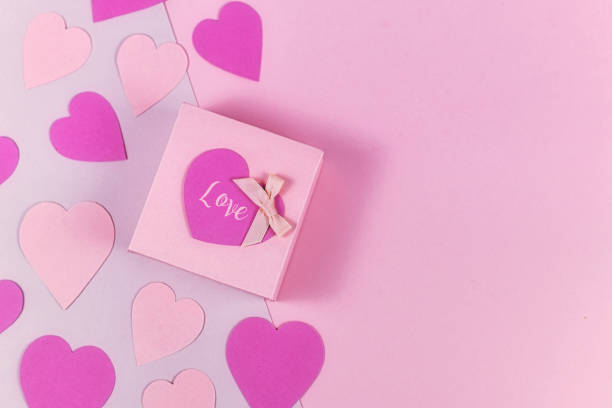 istock Romantic Valentine's Day flat lay background with small pink gift box and word 'Love' with hearts on left side and blank copy space on right side 1200772355