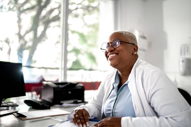 feliz mujer madura doctora sonriendo a paciente en la cita médica - prescription plan fotografías e imágenes de stock