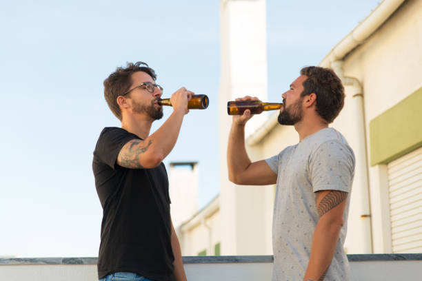 istock Side view of two handsome young man drinking beer 1200772499