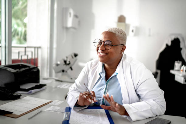 Happy mature doctor woman smiling to patient on medical appointment Happy mature doctor woman smiling to patient on medical appointment dermatology photos stock pictures, royalty-free photos & images