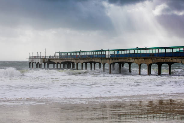 Boscombe pier on a stormy day illuminated by sunbeams breaking through a dark cloudy sky. stock photo