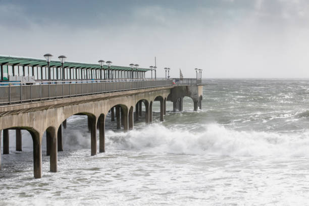 Boscombe Pier on a bright day with heavy seas breaking on to shore. stock photo