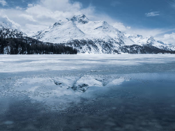 istock Snow-capped mountain peak reflected into an alpine lake 1200774044