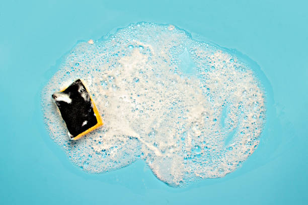 istock Soap foam from a cleaning agent and a cleaning sponge on a blue background. Cleaning concept, cleaning service. Flat lay, top view 1200775164