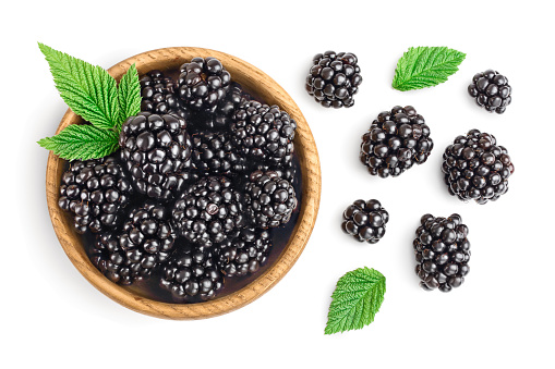 blackberry with leaf in wooden bowl isolated on a white background closeup.