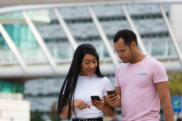 istock Cheerful people talking and looking at phones during stroll 1200775420