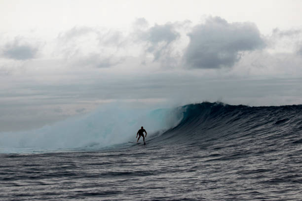 istock Surfer riding perfect wave at sunrise 1200775646