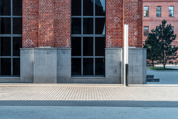 istock Facade of red brick office building with large windows. Modern brick architecture. Urban office block design. No people. Pavement road. 1200775703