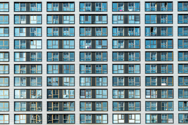 istock White facade of a residential multi-storey building with large windows. Modern architecture. Real estate in a big city. Background from the wall of the house. 1200775852
