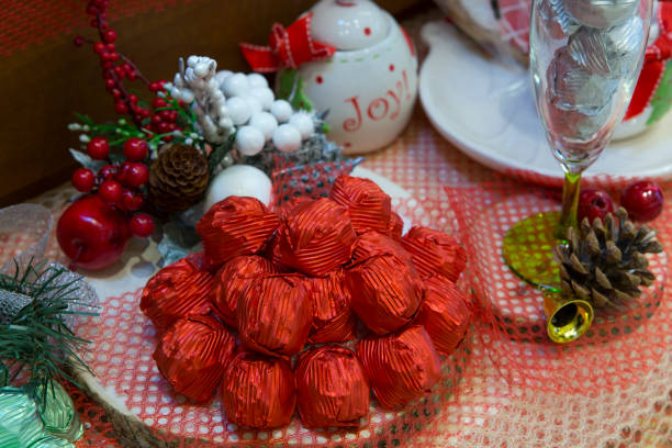 istock New Year special decoration. Red packed chocolates, white ceramic sugar bowl, cones. Celebrations, Christmas concept. Horizontal close-up. 1200776609