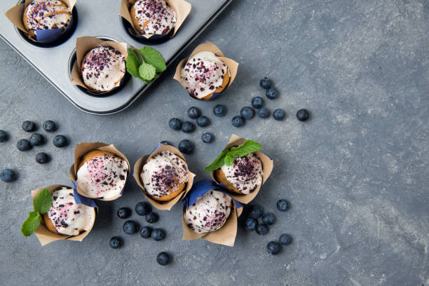 istock Homemade blueberry muffins with white chocolate and fresh blueberries on stone grey table, top view 1200778024