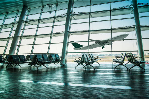 istock Empty airport departure lounge and airplane take off 1200778357