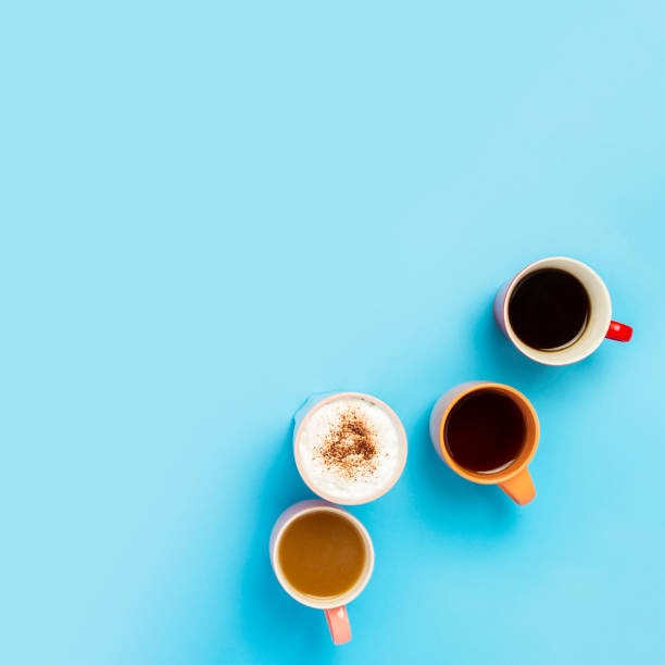 istock Cups with hot drinks, coffee, cappuccino, coffee with milk on a blue background. Concept coffee shop, meeting friends, breakfast with friends, friendly team. Square. Flat lay, top view 1200778476