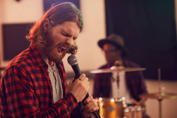 istock Bearded Young Man Screaming to Microphone 1200778991