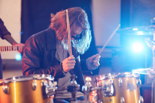 istock Long Haired Man Playing Drums in Stage Lights 1200779167