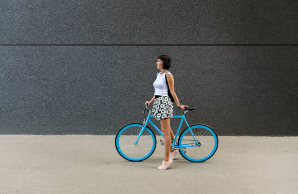 istock Cute girl standing on toes and posing with her bicycle 1200780387
