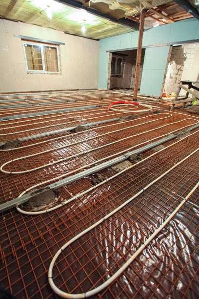 istock Pipefitter installing system of heating or underfloor heating installation. Water floor heating system interior. Plumbing pipes in apartment during under construction, remodeling, renovation, extension, restoration, reconstruction, upgrade 1200781248